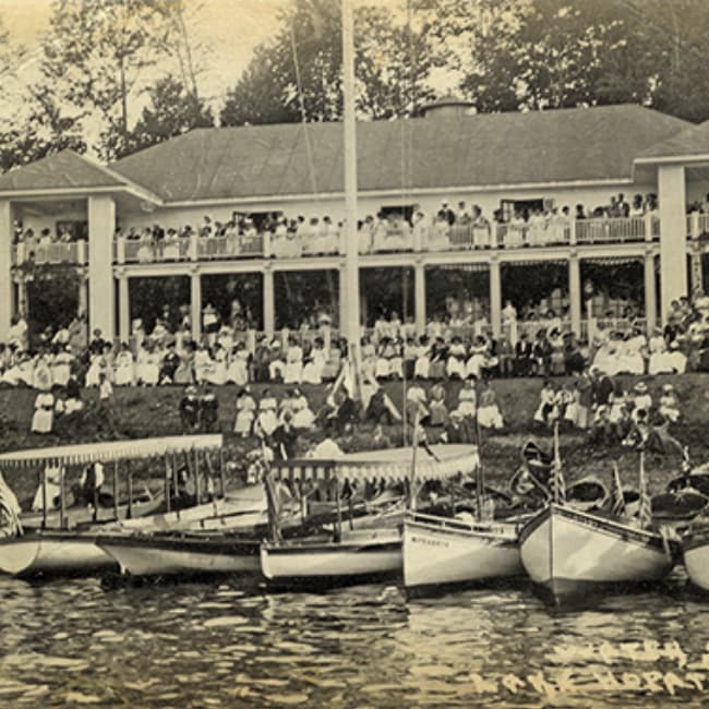 A sepia photo of an old lake hotel